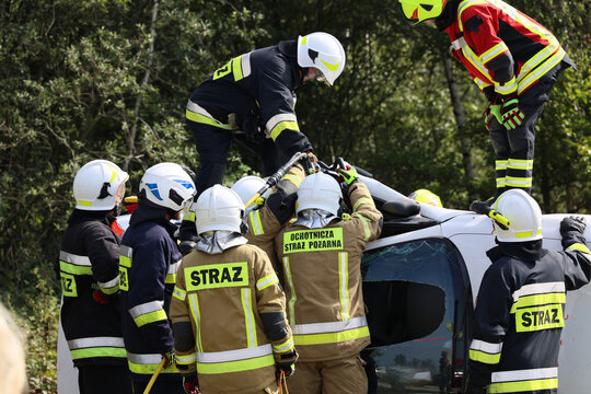 Funkcjonariusz straży pożarnej podczas akcji ratunkowej przy wypadku samochodowym. 