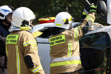 Funkcjonariusz straży pożarnej podczas akcji ratunkowej przy wypadku samochodowym. 