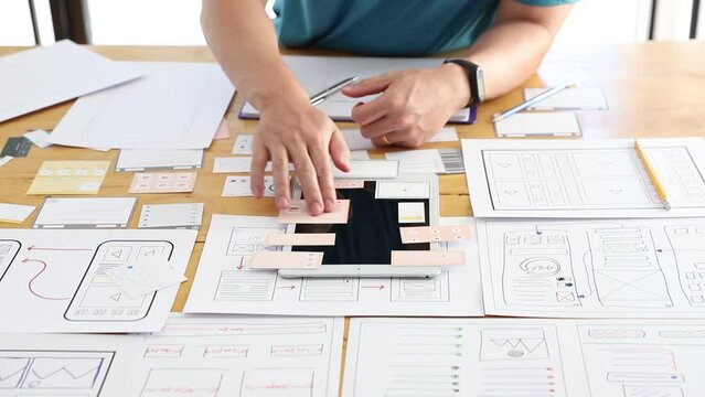 UX UI Concept, Graphic designers work together with UX UI designer planning application template layout framework for mobile phone computer mobile