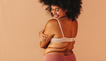 Self-loving plus size woman embracing her natural body - obrazy, fototapety, plakaty