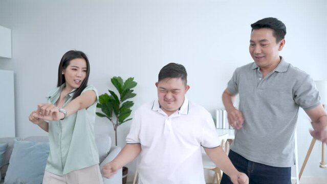 Happy Asian family doing activities together at home on vacation, Caring and encouraging special children, Down syndrome, Autism.