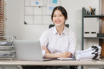 Obraz na płótnie Canvas Happy attractive joyful asian woman working at workstation.