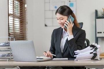 Happy attractive joyful asian woman working at workstation.