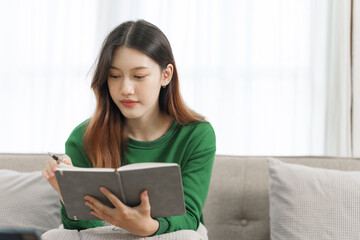 Happy young attractive smiling asian woman enjoying relax time at apartment.