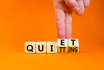 Quiet quitting symbol. Concept words Quiet quitting on wooden cubes. Businessman hand. Beautiful orange table orange background. Business quiet quitting concept. Copy space. - obrazy, fototapety, plakaty