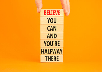 You can symbol. Concept words Believe you can and you are halfway there on wooden blocks on a beautiful orange table orange background. Businessman hand. Business motivational and you can concept. - obrazy, fototapety, plakaty