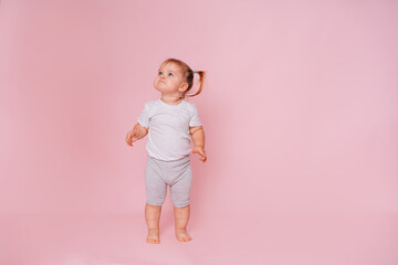 Cute little happy girl Standing and looking up on a pink background, Advertising of children's goods