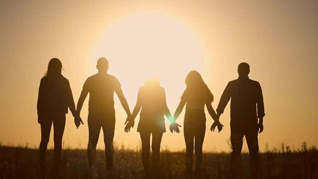 teamwork. team community a holding hands together silhouette at unity sunset. group of people hands. teamwork of workers. team in lifestyle the company running partnership business community hand