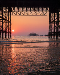 Sunset inbetween Brighton Pier with a view of West Pier.