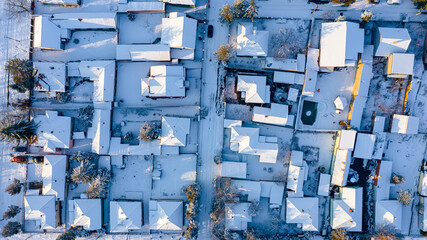 Aerial top view on cityscape covered with snow, appearance of the city in winter.