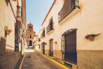 Church Street in the village of Lubrin, where the perspective leads the view to the door under the bell tower of the church.