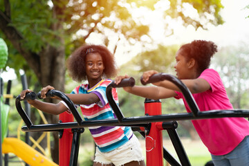 Obraz premium Smiling two African American child girl playing together at the playground. Happy girls having fun at the playground outdoor