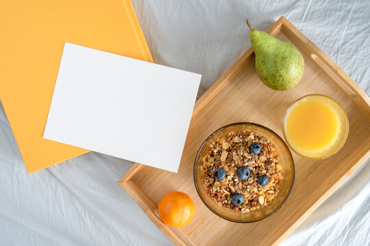 breakfast in bed, breakfast on a tray, muesli and fresh fruit, orange juice, invitation with space for text, photo from above