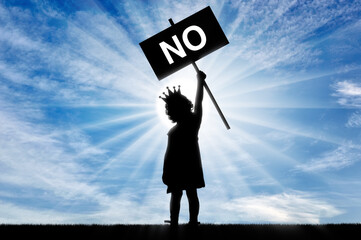 Girl child egoist with a crown on his head holds a poster with the word no.