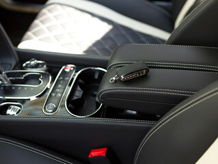 Fototapeta na wymiar black and white leather interior in a luxury car with a key on the armrest