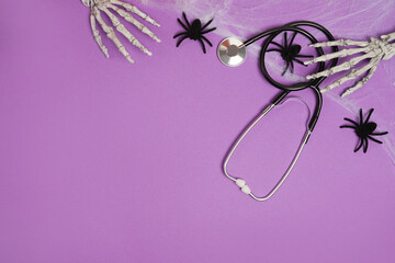 Halloween decor and stethoscope on violet background with copy space. Medical Halloween in the hospital