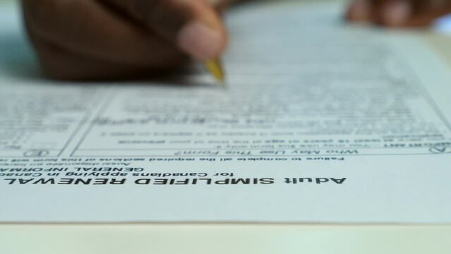 Black african hand filling out USA passaport application form.Migration,USA