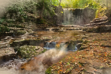 Epic beautiful Autumn landscape image of Nant Mill waterfall in Wales with glowing sunlight through the woodland