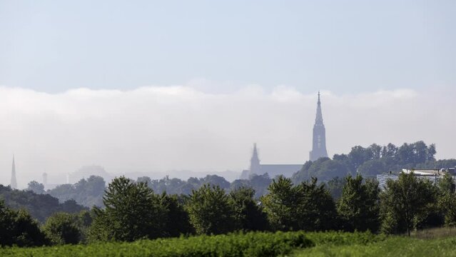 Time lapse shot of Ulm minster covered in fog and revealing from time to time