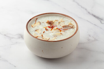 Close-up of Creamy Sabudana Kheer Garnished with saffron and dry fruits. Indian delicious dessert. Served in ceramic bowl.