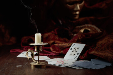 Still life with an extinguished candle, playing cards, and carnival masks.