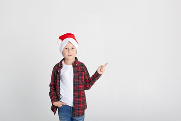 Smiling little boy in Santa's hat with gift box, isolated on white.