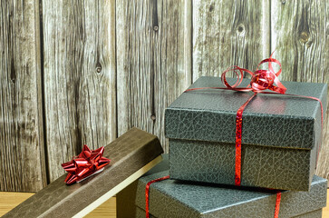 Christmas gifts with red ribbon on table and wood background 