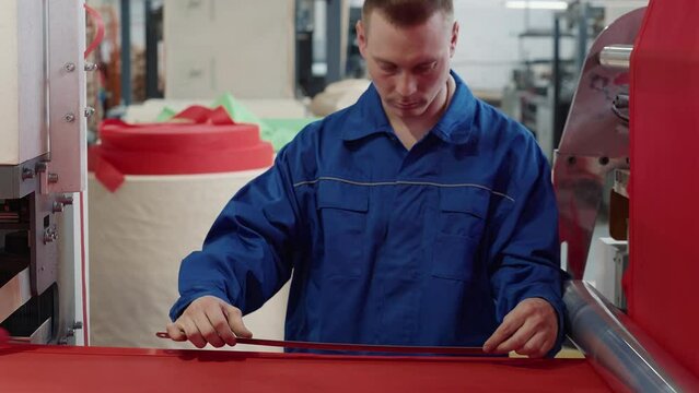 Professional Factory Engineer Measuring Fabric Product Using Ruler Tool. Engineer Measuring Product Produced By Automated Machine. Engineer Measuring Textile Material To Ensure Good Product Quality