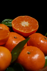 close up of mandarins with leafs, dark background