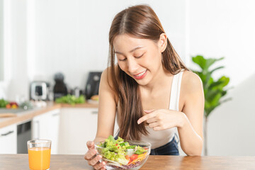 Obraz na płótnie Canvas Diet, Dieting, pretty slim asian young woman or girl smiling, looking at mix vegetables, green salad bowl, eat vegetarian food is low fat good healthy. Nutritionist weight loss for health person.