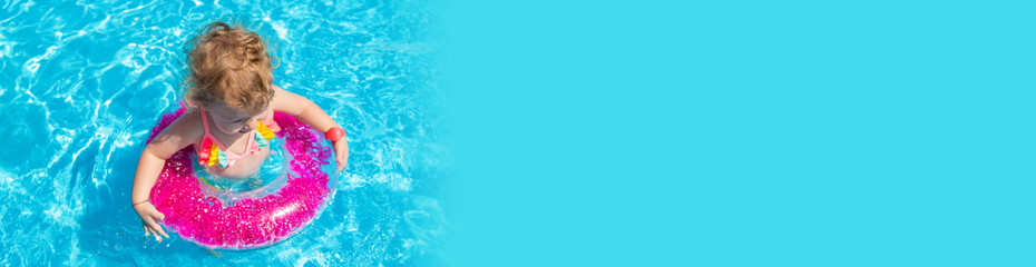 A child swims in a pool with a circle. Selection focus.