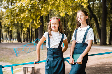 Naklejka premium Two pupils in school uniform enjoy a walk in the park on a warm day