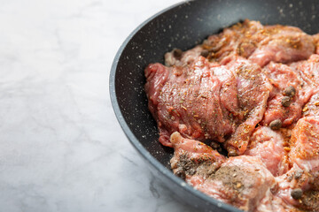 Fresh raw beef steaks with onions and peppers on a frying pan. Roast beef.
