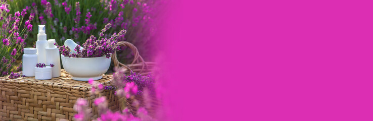 Obraz na płótnie Canvas Lavender cosmetics in a field with flowers. Selective focus.
