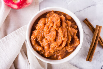 Applesauce with cinnamon in a bowl and fresh fruit on the table. Organic food. Top view. Closeup
