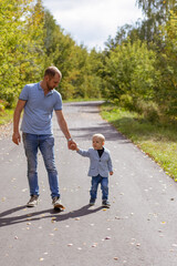 fashionable toddler son with father walking
