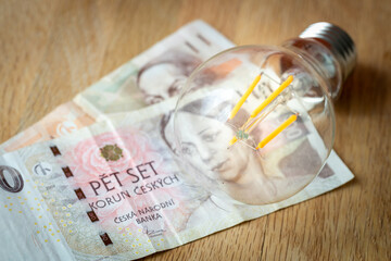 Czech money CZK 700 and a light bulb, concept of rising energy and electricity prices in Czech Republic