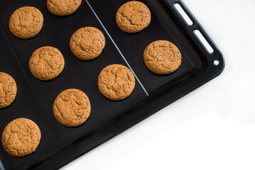 Homemade oatmeal cookies, freshly cooked on a baking sheet from the oven. The concept of a home bakery, natural healthy cookies on a white background. Copy space for text