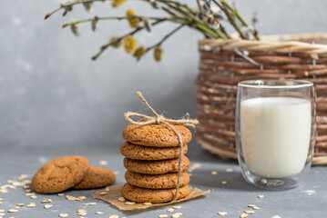 homemade oatmeal cookies on a wooden tray with burlap in a rustic style. Spring composition with a basket with a willow. The concept of a home bakery, proper and healthy nutrition. Copy space for text