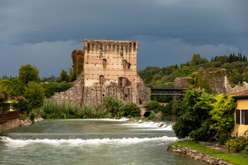 Borghetto Scaligeri Castle waterfalls and bridge on a heavy cloudy day in the village of Valeggio...
