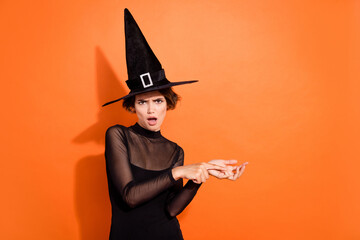 Photo of impressed shocked girl dressed black gothic dress headwear counting fingers empty space isolated orange color background