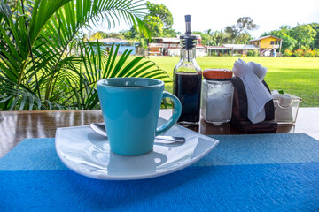 Fototapeta na wymiar Taza de café en la mesa de un hostel en Tortuguero, Costa Rica 