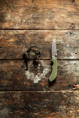 Knife and flint. Tourist folding knife and steel for kindling the fire. Travel items on an old...