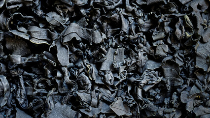 Dried cut wakame seaweed flakes background texture. Asian cuisine ingredient.