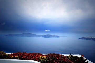 Mist on the Santorini Island, Greece. View of the Mediterranean Sea in the morning haze. Filmed during a trip to the Mediterranean and the Cycladic Archipelago. From the shore. Among the flowers. 