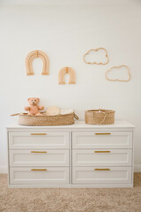 White and Cream gender neutral nursery with boho decor, teddy bear, wicker changing basket, white...
