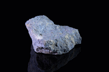 A piece of the raw mineral dumortierite is bluish in color with gray and white patches