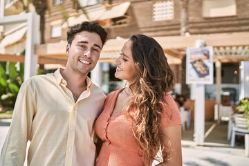 Man and woman couple smiling confident and hugging each other at street