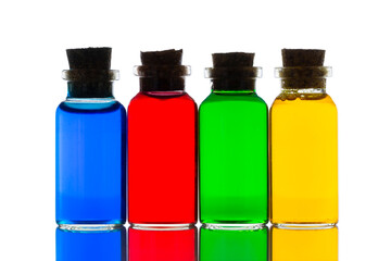 Mini glass bottles with corks filled with colored water on white background