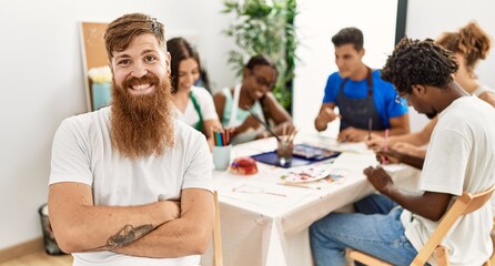 Group of people drawing sitting on the table. Caucasian man smiling happy looking to the camera at art studio.